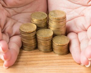 Persona sosteniendo un montón de monedas